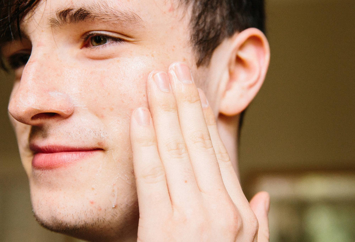A light layer of smooth, orchid white Cosmetic Lad facial moisturiser is rubbed across one half of a smiling face.